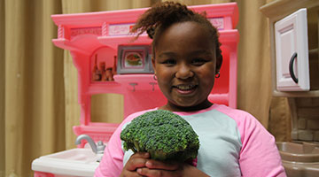 YMCA girl poses with broccoli
